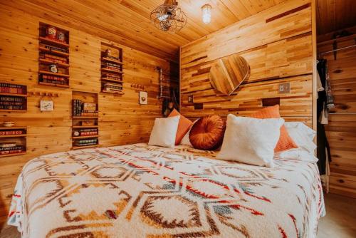ポート・エンジェルスにあるGreenpoint Getawayの木製の壁とベッドのある寝室