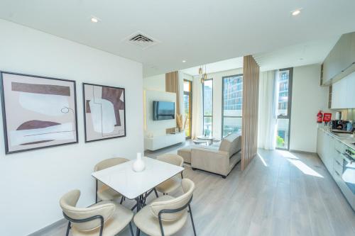 a living room with a table and chairs at Midtown Haven Cozy One Bed in Dubai in Dubai
