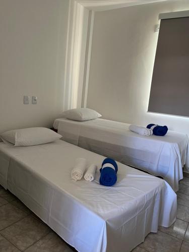 two beds in a room with blue towels on them at Apartamento em Uberlândia - Apê do Pedro in Uberlândia