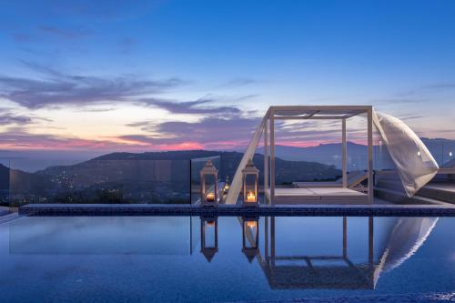 プサロウにあるColours of Mykonos Luxury Residences & Suitesの建物の上にガゼボ付きのプール