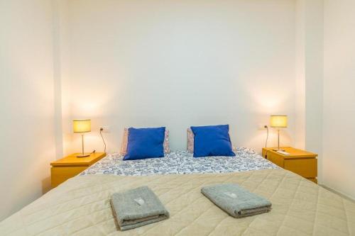 een slaapkamer met een groot bed met 2 blauwe kussens bij Apartment Siyar verde Rojales Benijofar 2 bedrooms with communal pool in Rojales