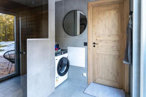 a laundry room with a washing machine and a mirror at Kuusemäe Puhkemaja in Rägavere