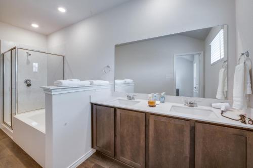 y baño con 2 lavabos, ducha y espejo. en Chic Mesquite Townhome about 11 Mi to Downtown Dallas!, en Mesquite