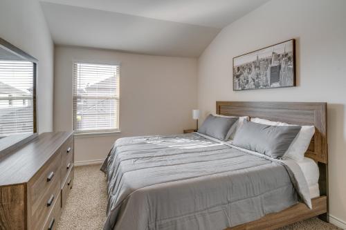 a bedroom with a large bed and a dresser at Chic Mesquite Townhome about 11 Mi to Downtown Dallas! in Mesquite