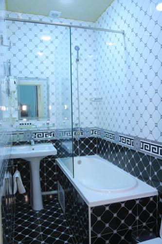 uma casa de banho com uma banheira, um lavatório e um espelho. em Evraziya business hotel em Bukhara
