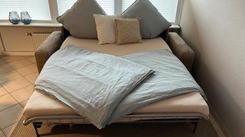 una cama con almohadas encima en Ferienwohnung Dock 19 in Büsum, en Büsum