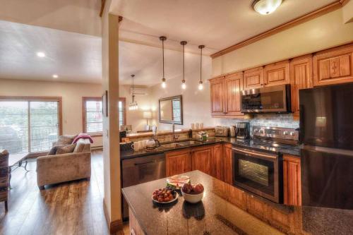 a kitchen with wooden cabinets and a table with fruits on it at Plateau A - Mont-Tremblant in Mont-Tremblant