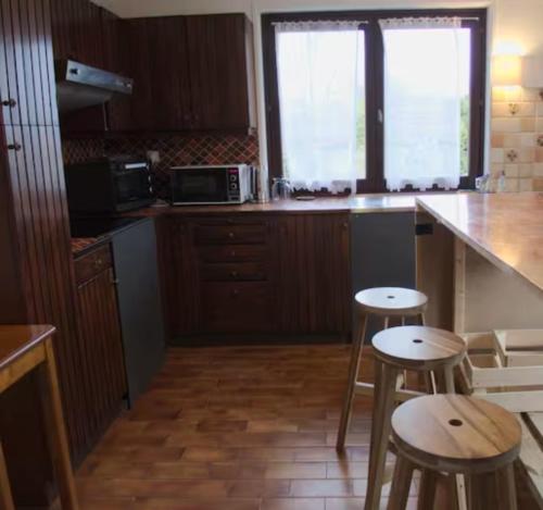 una cocina con barra y dos taburetes. en Floral en Divonne-les-Bains