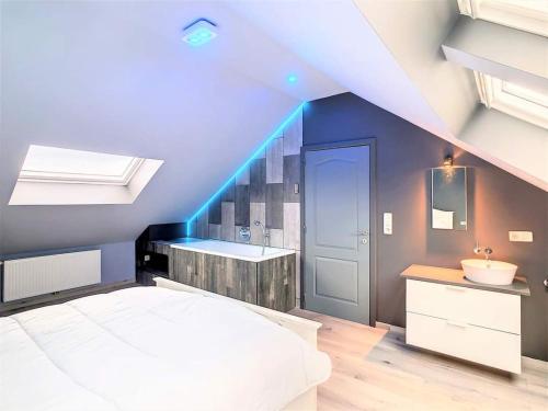 a bedroom with a bed and a sink and a bathroom at la grange in Gesves