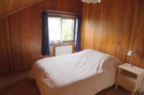 une chambre avec un lit blanc et une fenêtre dans l'établissement Magnolia, à Divonne-les-Bains