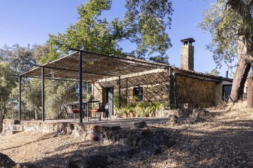 a stone cottage with a table and chairs in front of it at Pozuelo 1 JABUGO in Jabugo