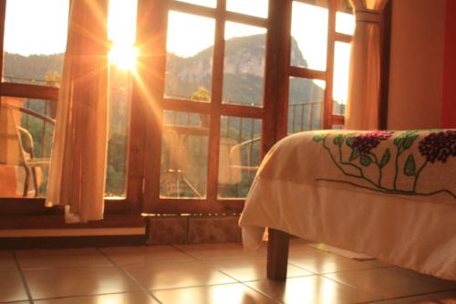 a bedroom with a bed and a window with a view at Hotel San Jorge in Tlatlauquitepec