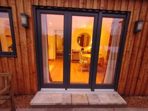 a sliding glass door in a room with a table at City Central Quiet Garden Studio with Free Parking in Inverness