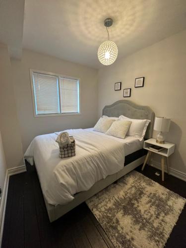 a bedroom with a large white bed with a rug at Cozy-2bedroom in Oakville in Oakville