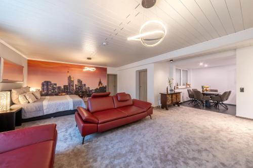 ein Schlafzimmer mit einem Bett und einem roten Sofa in der Unterkunft PMC Business Apartments in Rüsselsheim