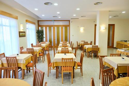 ein Esszimmer mit Tischen und Stühlen in der Unterkunft Hotel O Guerreiro in Ponte da Barca