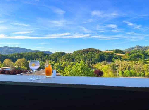 two glasses of orange juice on a table with a view at Hotel O Guerreiro in Ponte da Barca