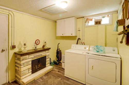 cocina con chimenea, lavadora y secadora en Charming Cabin in Mountain View with Deck!, en Mountain View