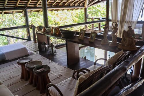 a room with a table and chairs and a bed at Ilha privativa - Rio Paraguaçu in Cachoeira