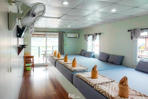 een groep bedden in een kamer met een ventilator bij เดอะวอเตอร์ปาร์ครีสอร์ท- The Water Park Resort in Ban Laem Mong Khoi
