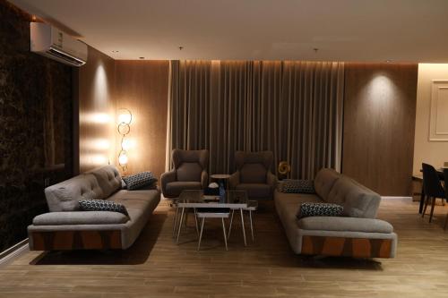 a living room with couches and a table in a room at شقق الماسة التاج للشقق الفندقية in Hail