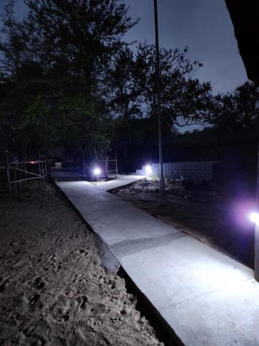 a sidewalk with lights on it at night at Amare Cabin in the bush with all your needs! in Marloth Park