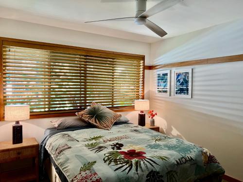 a bedroom with a bed with two lamps and a window at Loloma! Luxe 4 bed, 2 bath Villa in Yamba