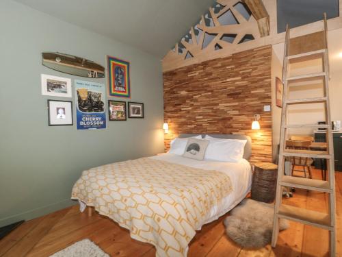 een slaapkamer met een bed en een houten vloer bij Pear Tree Lodge in Langport