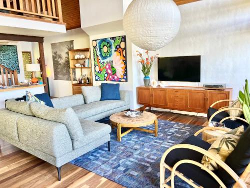 a living room with a couch and a tv at Loloma! Luxe 4 bed, 2 bath Villa in Yamba