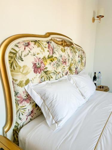a bed with a floral headboard with a white pillow at Chalet do Eléctrico 92' in Sintra