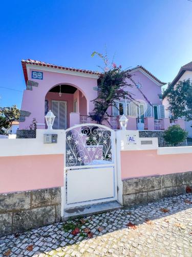 uma casa cor-de-rosa com um portão à frente em Chalet do Eléctrico 92' em Sintra