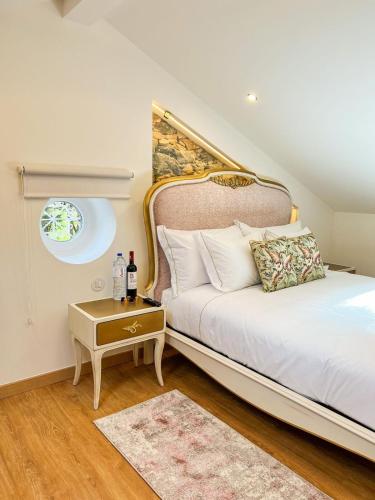 a bedroom with a bed and a table with a bottle of wine at Chalet do Eléctrico 92' in Sintra