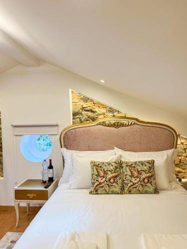 a bedroom with a white bed with a large headboard at Chalet do Eléctrico 92' in Sintra