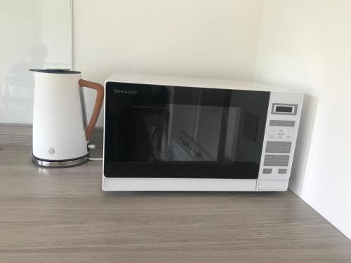 a microwave sitting on a counter next to a vase at City Central Quiet Garden Studio with Free Parking in Inverness