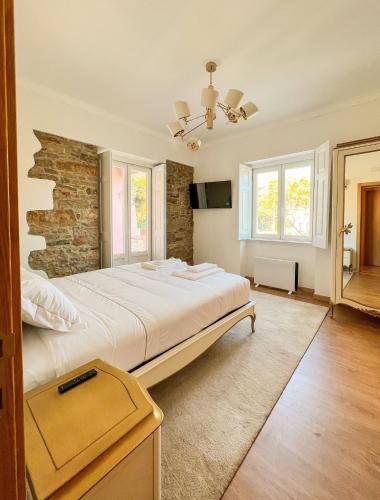 a bedroom with a large bed with a stone wall at Chalet do Eléctrico 92' in Sintra