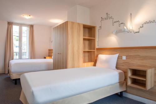 a hotel room with two beds and a cabinet at Au Pacific Hotel in Paris
