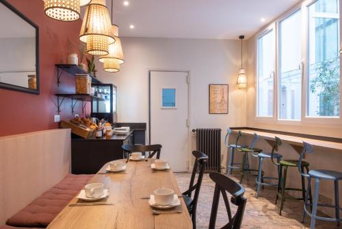 a restaurant with a long wooden table and chairs at Au Pacific Hotel in Paris