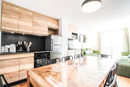 a kitchen and dining room with a table and chairs at Stunning 4-bedroom apartment Flaine Foret, fully refurbished, beautiful panoramic views in Flaine