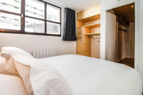 a bedroom with a white bed and a window at Stunning 4-bedroom apartment Flaine Foret, fully refurbished, beautiful panoramic views in Flaine