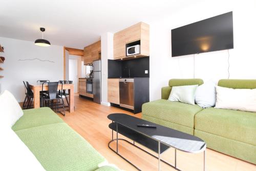 a living room with a couch and a table at Stunning 4-bedroom apartment Flaine Foret, fully refurbished, beautiful panoramic views in Flaine