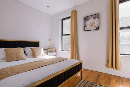 una camera con un grande letto e due finestre di 5-Bedroom NYC Apartment a New York