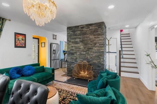 a living room with a green couch and a fireplace at Charming Salt Lake City Home Minutes from Airport, Downtown SLC , Skiing in South Salt Lake
