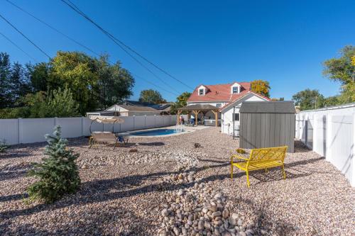a backyard with a yellow chair and a fence at Charming Salt Lake City Home Minutes from Airport, Downtown SLC , Skiing in South Salt Lake