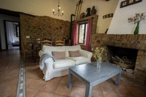 a living room with a white couch and a table at Pozuelo 2 JABUGO in Jabugo