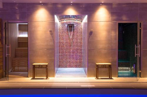 a bathroom with a shower with two stools at Ilsington Country House Hotel & Spa in Ilsington