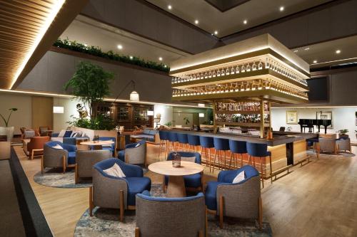 un restaurante con mesas y sillas azules y un bar en InterContinental Presidente Mexico City, an IHG Hotel, en Ciudad de México