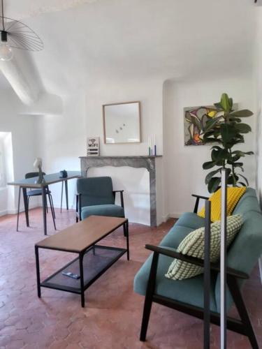 - un salon avec un canapé, des chaises et une cheminée dans l'établissement Logement au coeur de Marseille, le Stassi, à Marseille