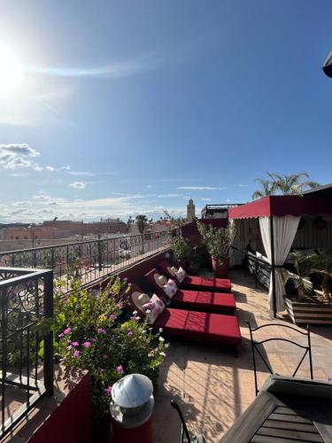 a balcony with two people laying on a red blanket at Dar L'hna in Marrakech