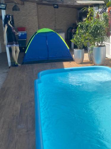 a blue and green tent next to a swimming pool at Tia Moni - diárias individuais in Blumenau
