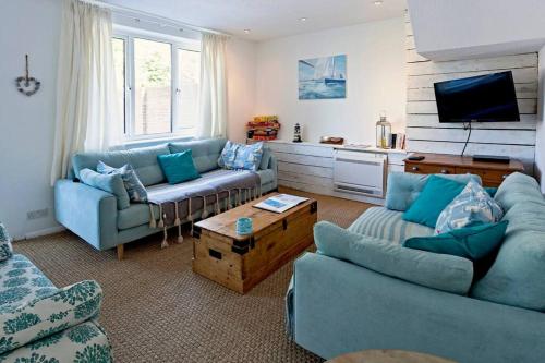 a living room with two couches and a tv at Gorgeous Comfy Cottage Walking Birdwatching Paddle Boarding and Seafood on the Doorstep in West Mersea